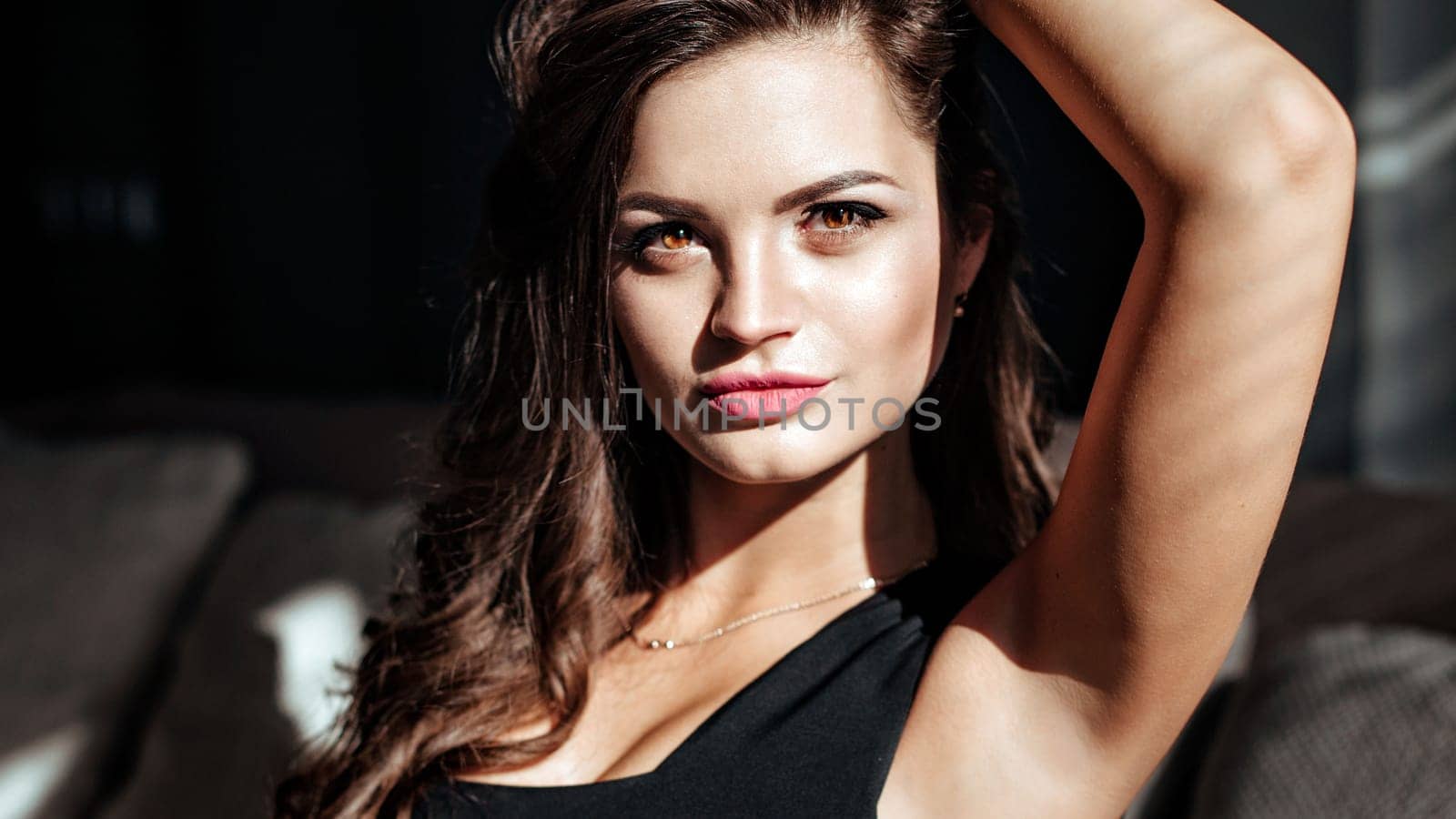 close-up of the seductive face of the brunette with beautiful makeup and sexy lips. luxurious hairstyle and flirtatious look.