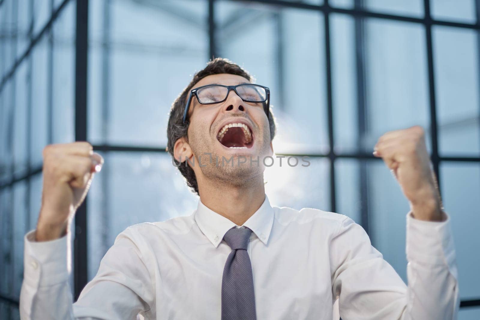 Millennial office worker standing in hallway clenched fists feel overjoyed celebrate career advancement