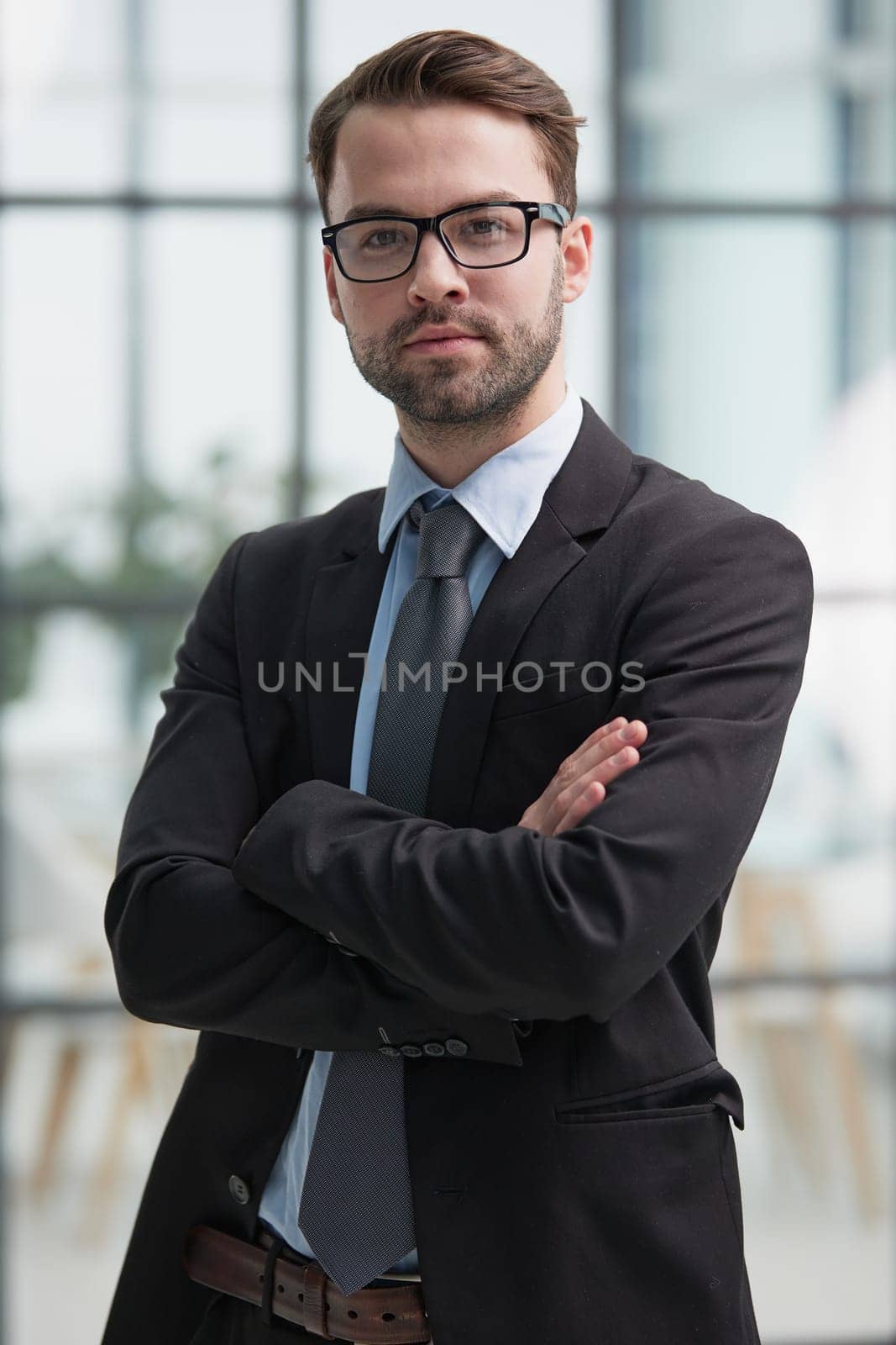 portrait of confident businessman with arms crossed in office