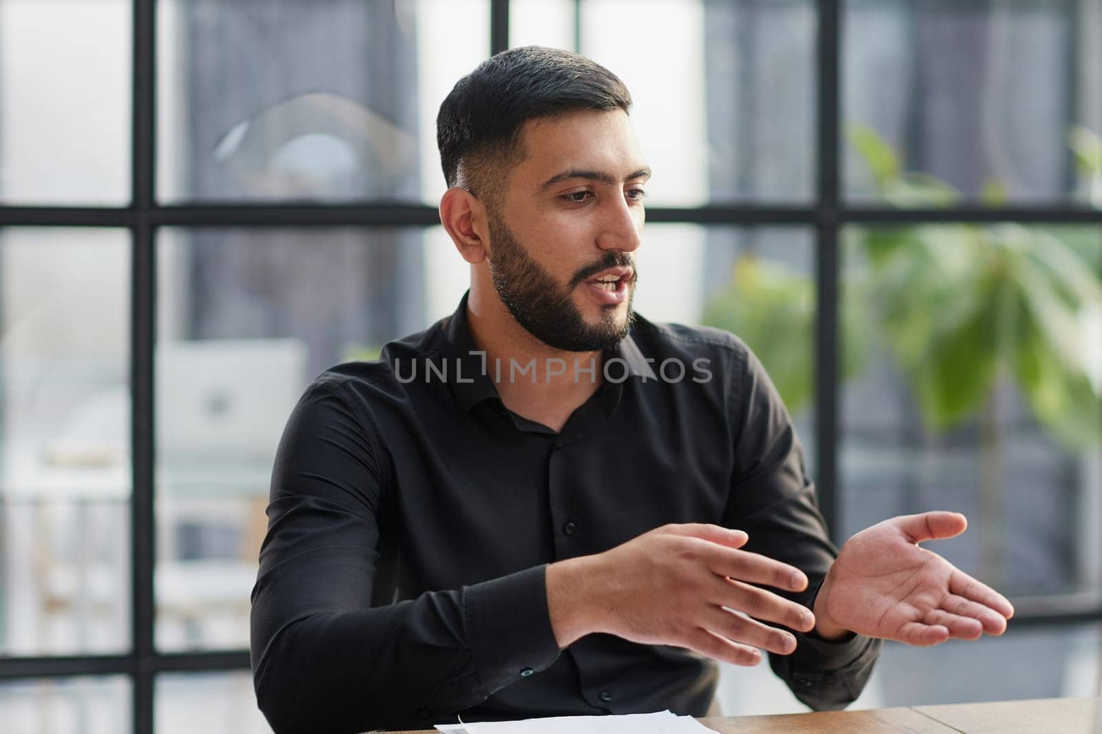 Positive businessman talking on headset at a computer