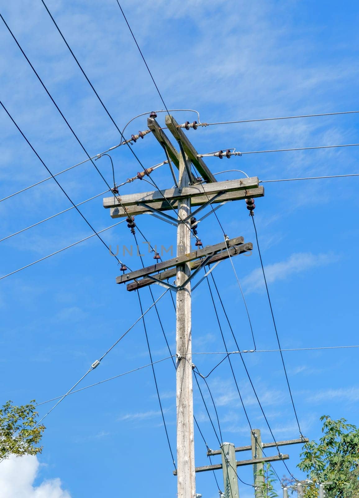 Electric pole and wires, wood electricty pole on blue sky background