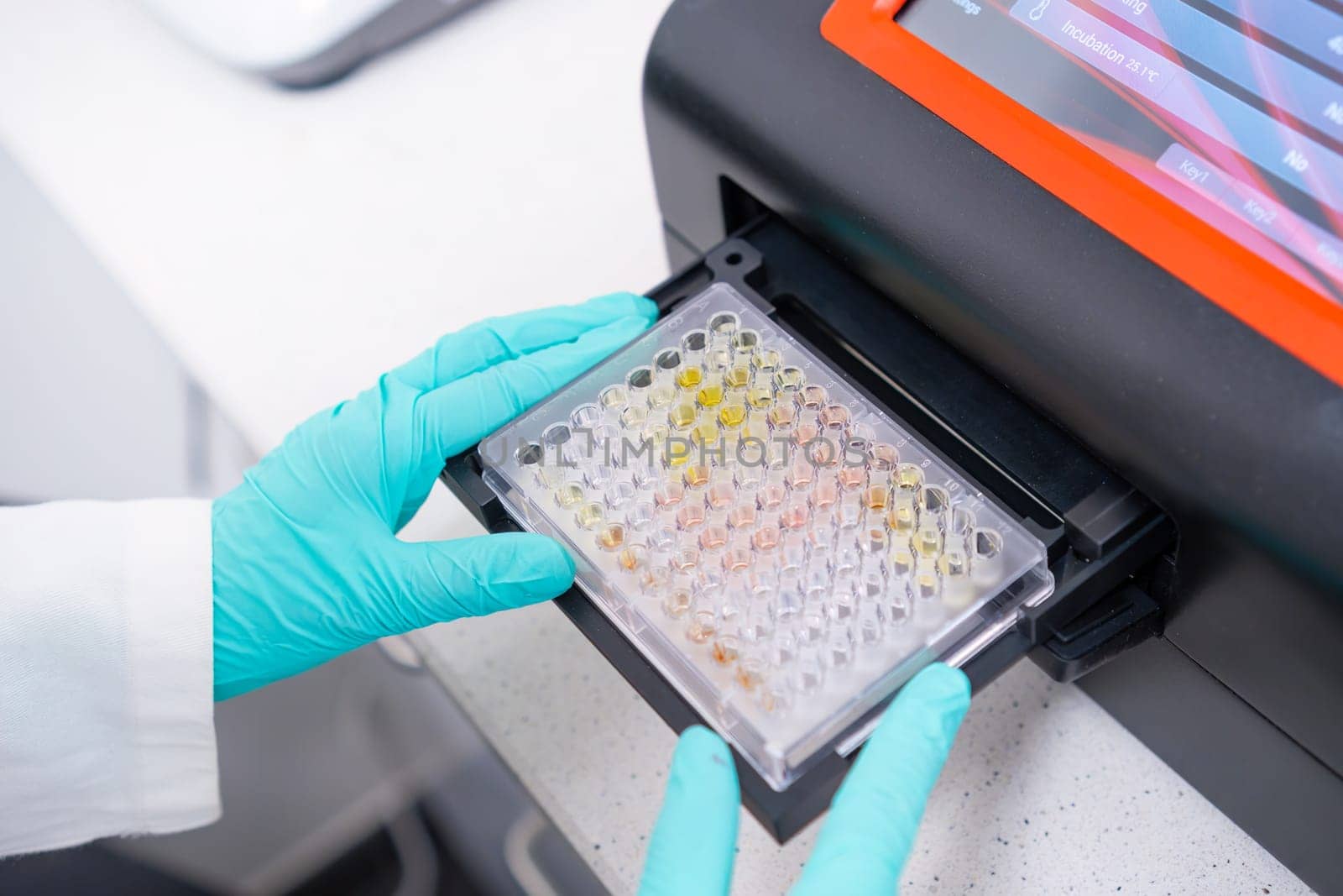 A microplate spectrophotometer is used by scientist to analyze DNA samples by inserting microplate. by vladimka