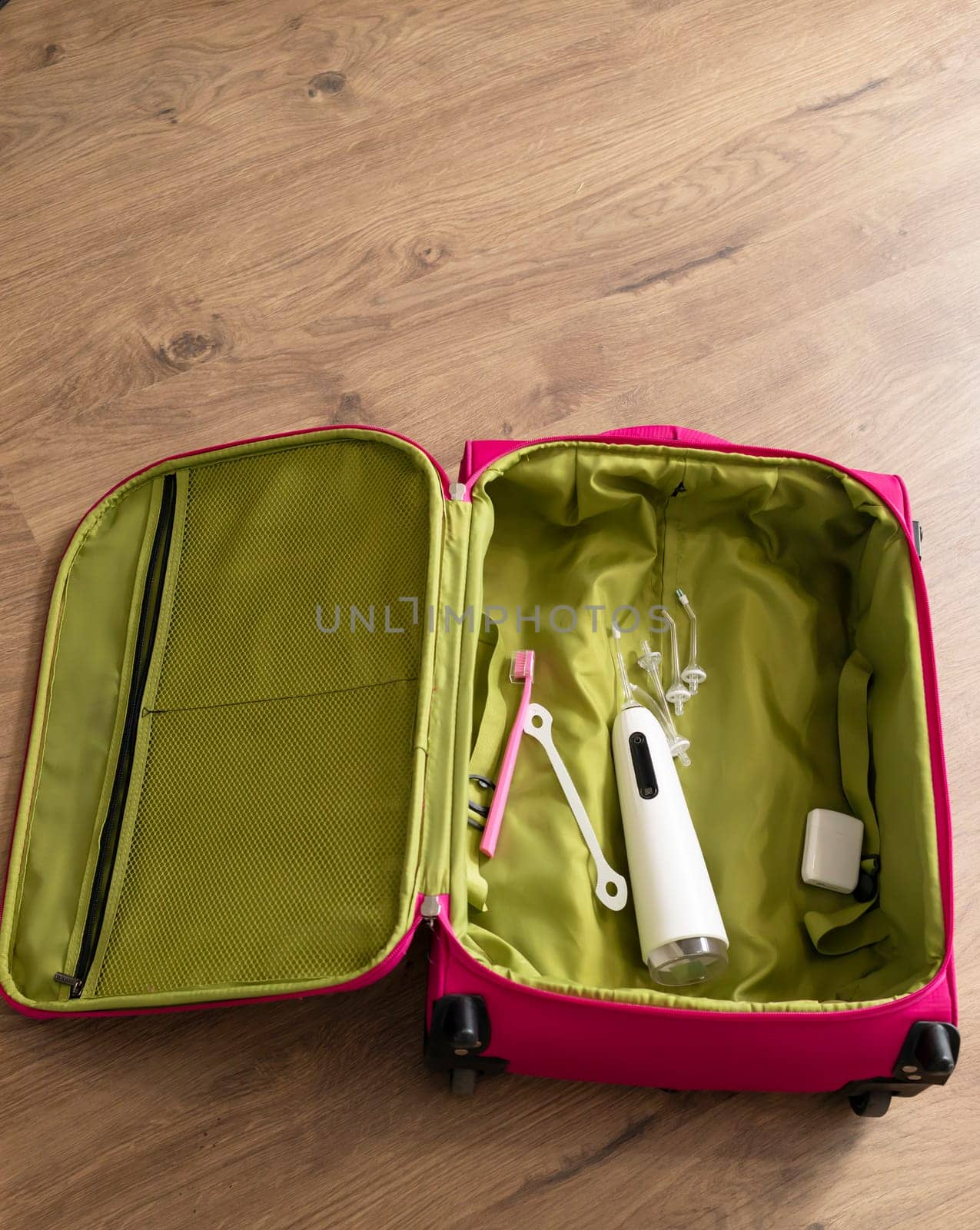 Dental teeth care set in handbag, travel concept. Water teeth irrigator with nozzle pack, toothbrush, floss in luggage on wooden floor. Home dental care device. Vertical plane by netatsi