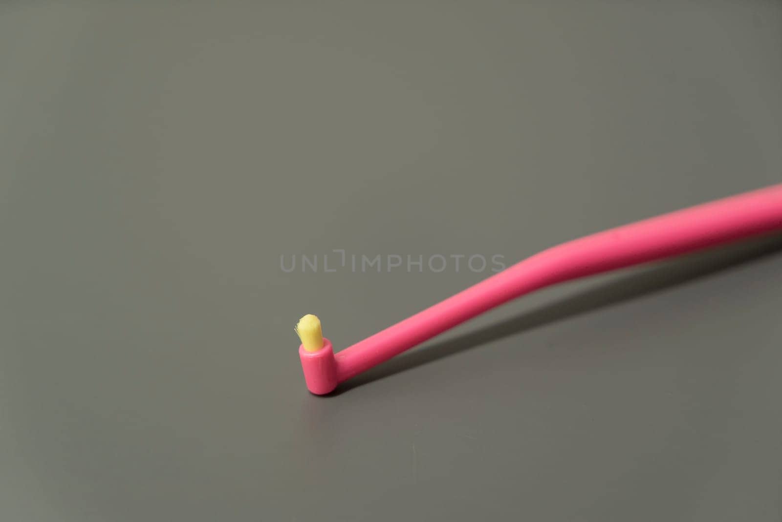 Plastic toothbrush on grey background. Blue and pink color brush. by lponline