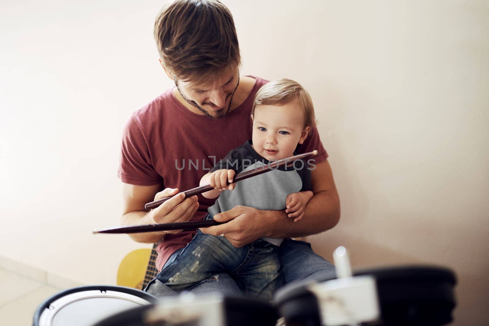 Happy father, baby and child drum lesson with music development and kids learning. Home, happiness and bonding with youth and dad together with a smile, instrument and parent care at a family house by YuriArcurs