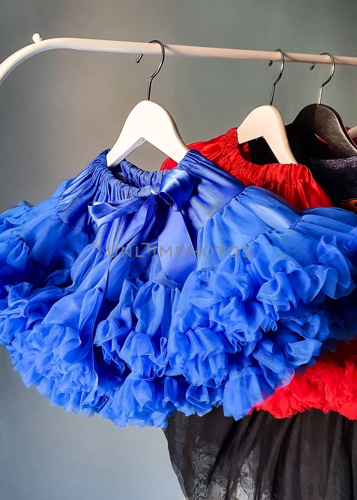 Fluffy skirts hang on a metal hanger. by Spirina