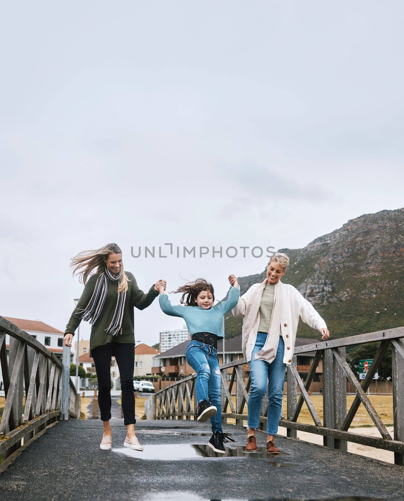 Happy, travel and family on outdoor walk while on a spring vacation, adventure or journey. Grandmother, mother and girl child walking on bridge together with happiness, fun and bond while on holiday