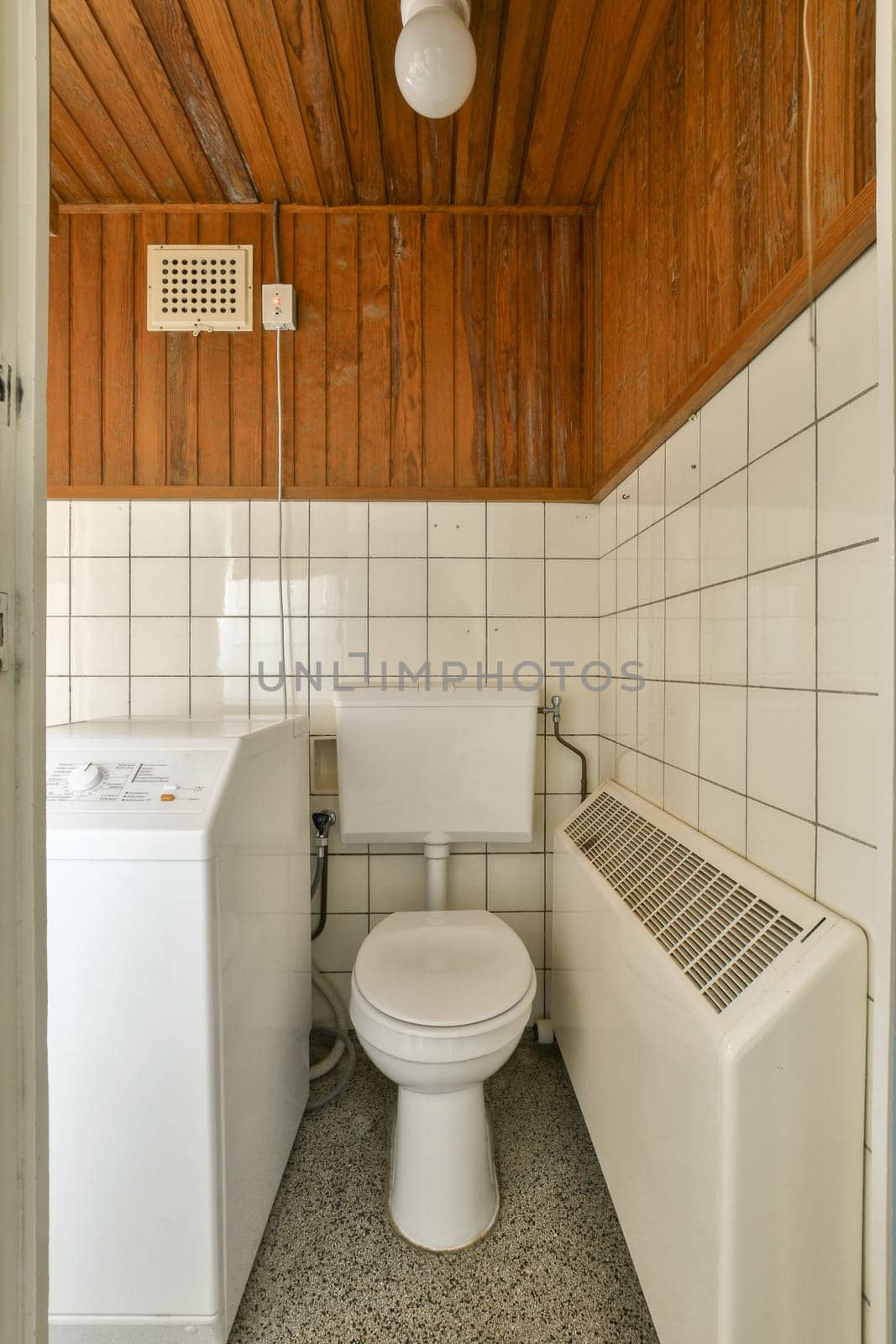 a small bathroom with wood paneled walls and white tile on the floor, there is a toilet in the corner