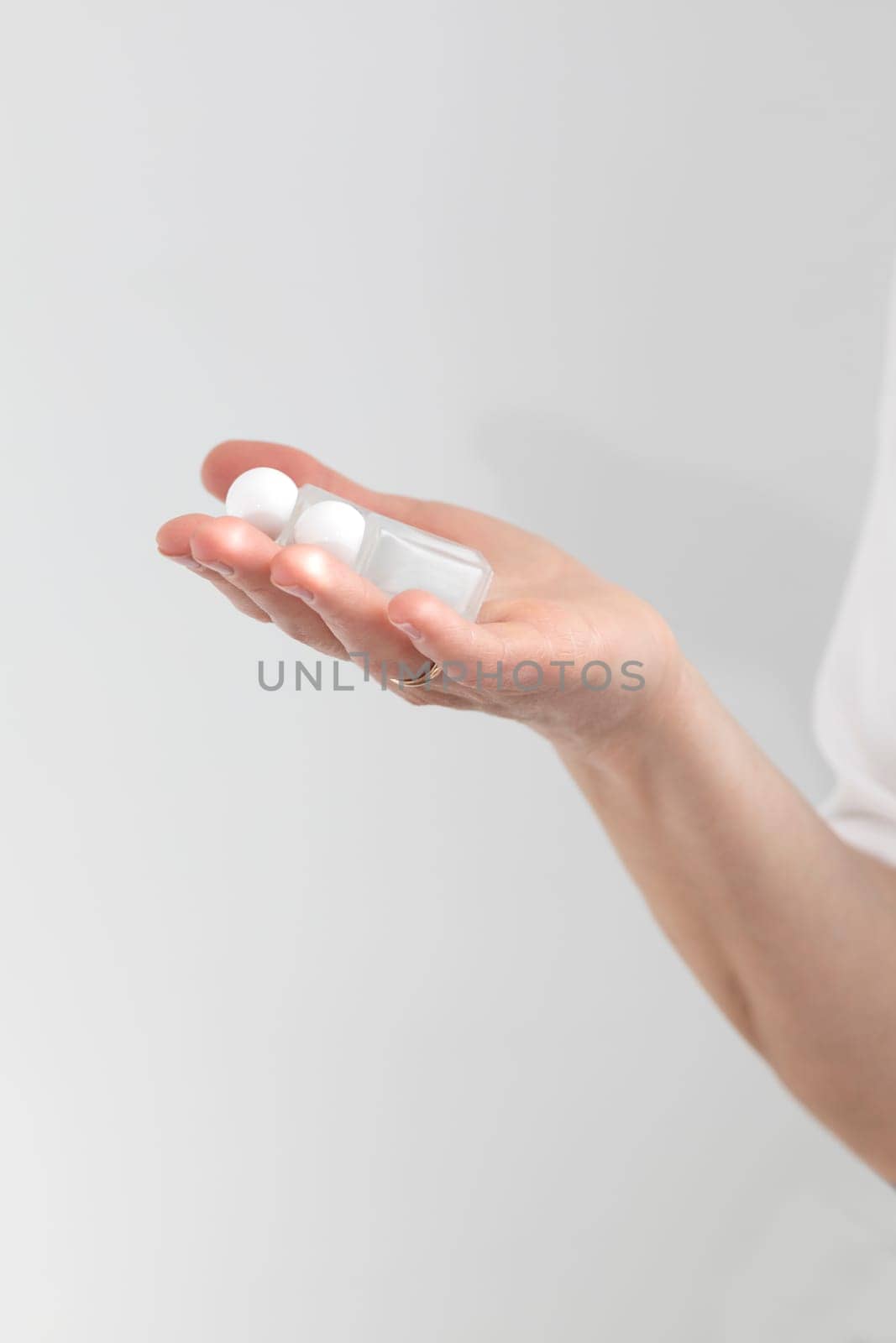Hand Holds Two Glass Bottles With Lash Lift Lotion For Eyelash Lamination Treatment Procedure. Curling, Staining, Extension Procedures For Lashes. Vertical Plane, Closeup.