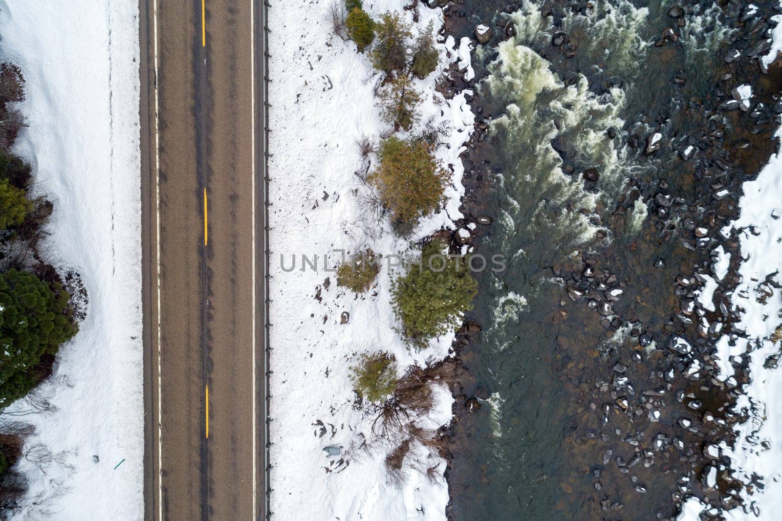 top down view of a snow landscape including a road next to a river