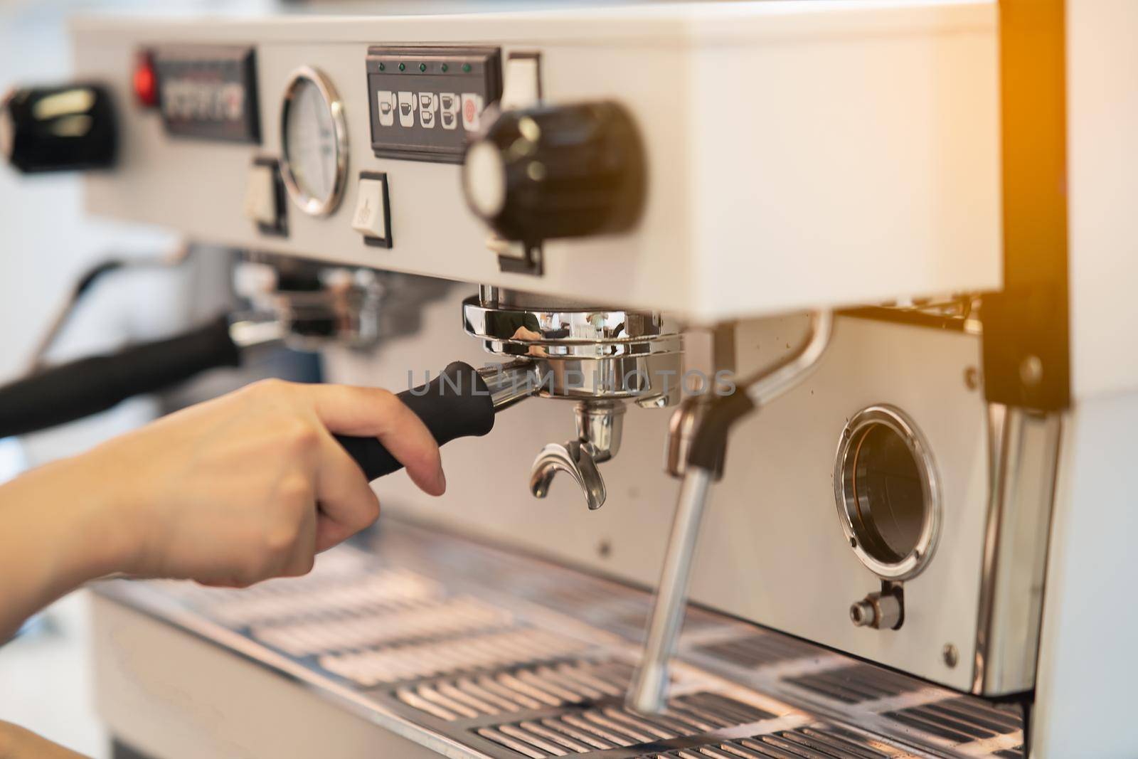 women barista making coffee in a coffee machine, coffee making concept by Wmpix