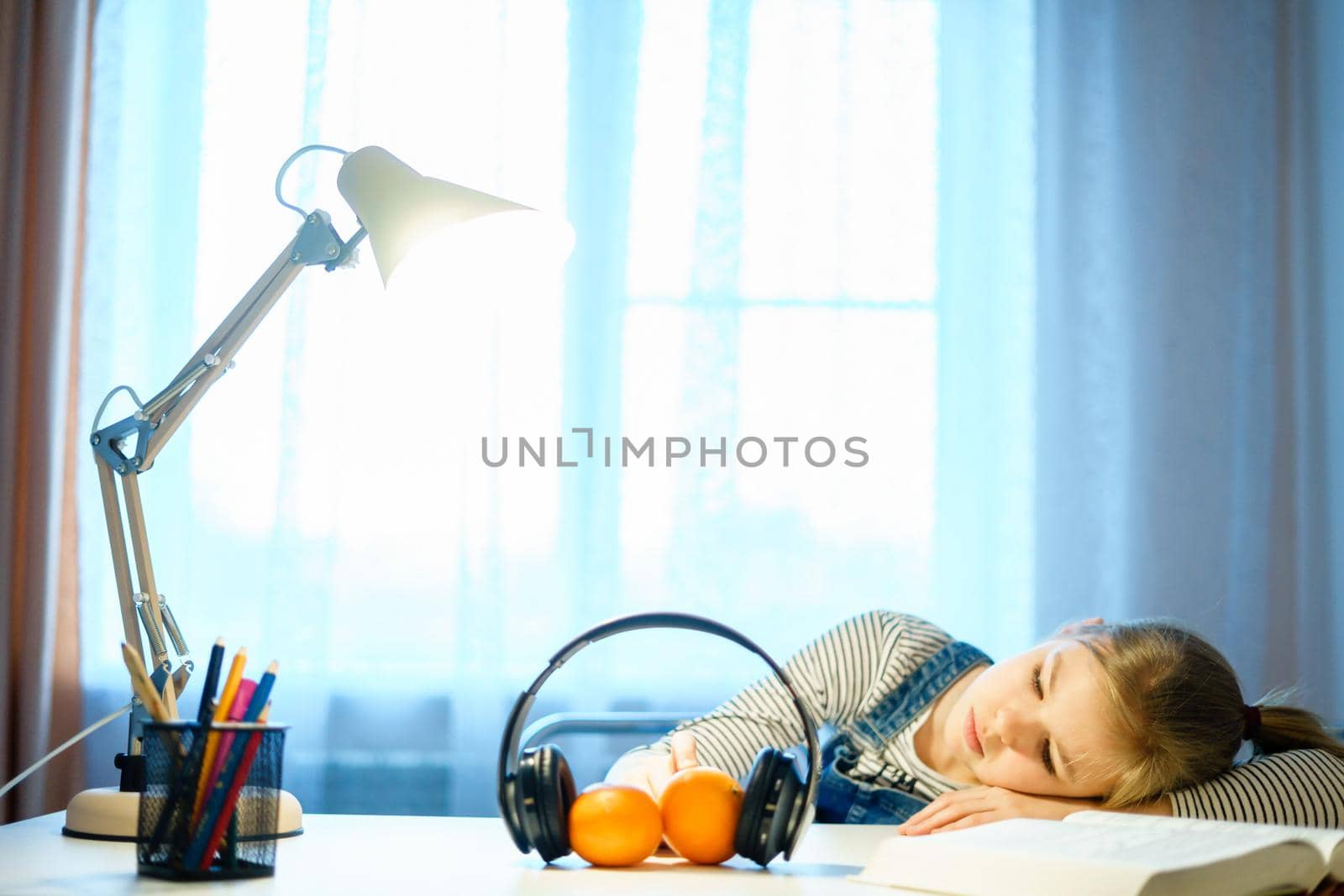 Student teenage girl lying on desk with books. young tired woman napping on her textbook. Tiredness, exhaustion, education, preparing for exams and test concept by Mariakray