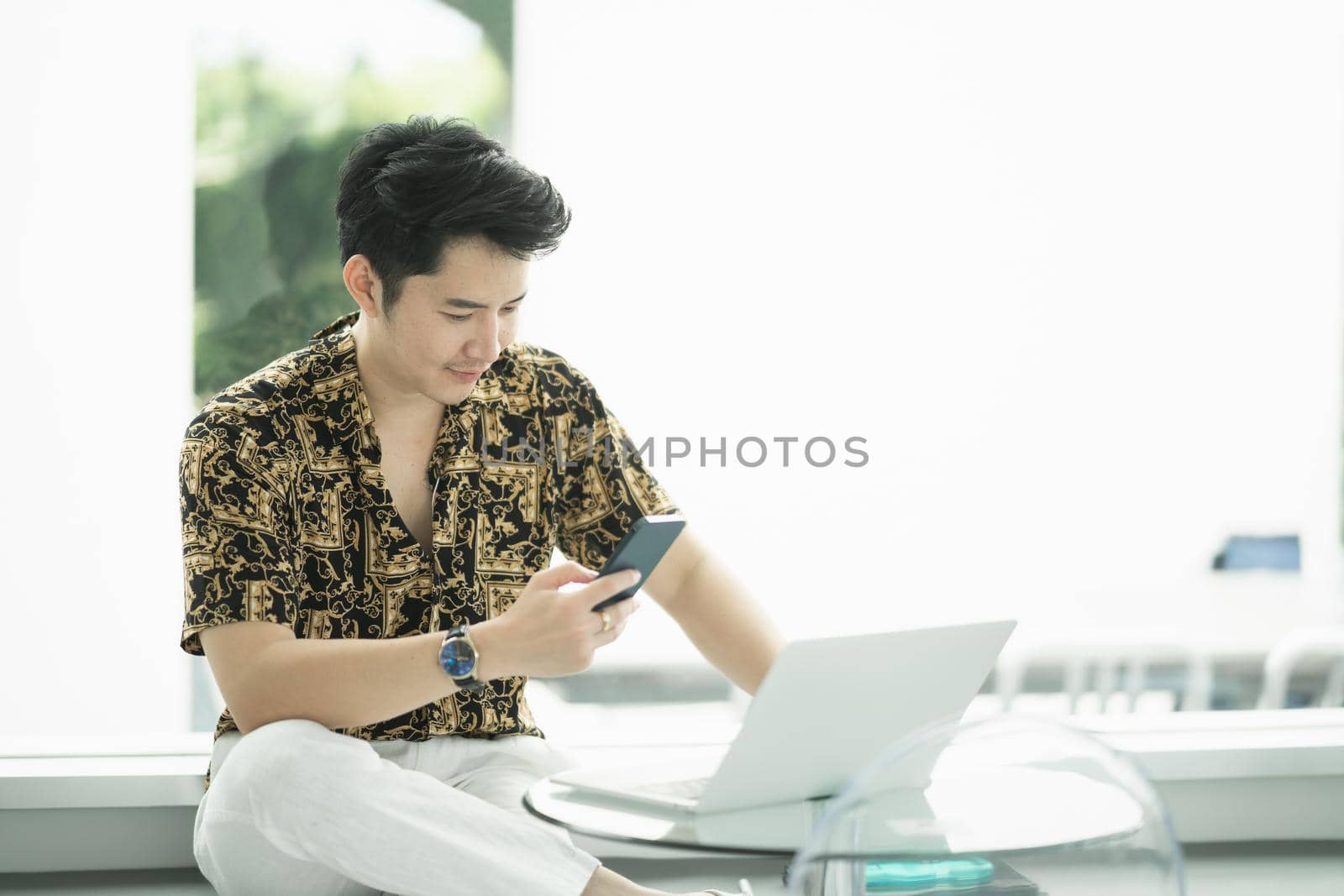 rich man using mobile phone and working with laptop at the cafe