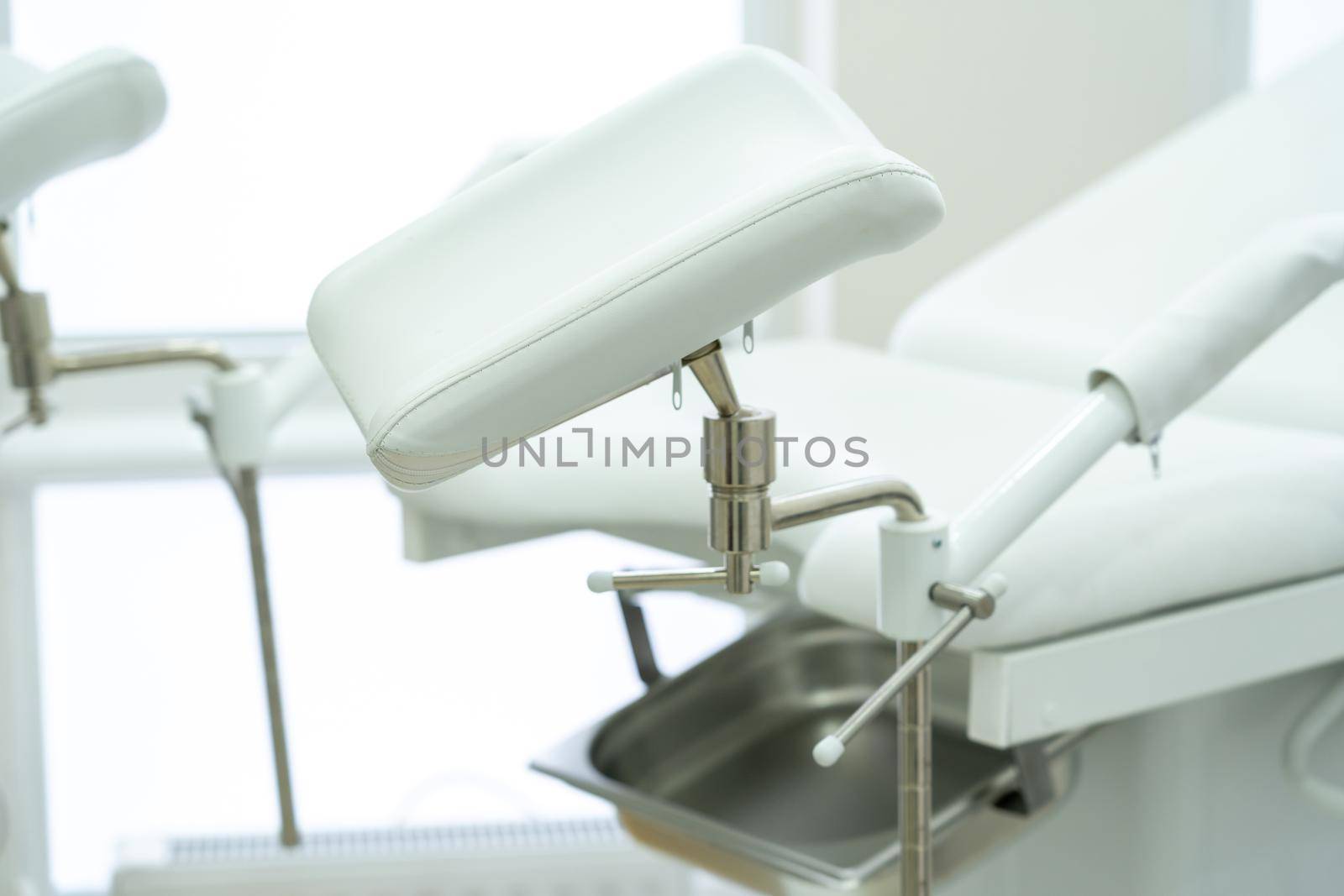 White gynecological chair in modern medical center by Mariakray