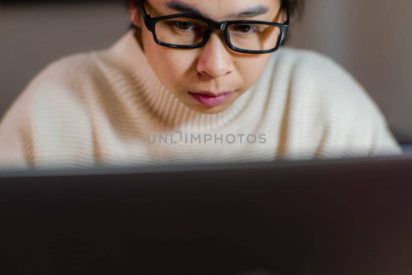 Busy businesswoman working on laptop computer in office. Confident young woman in casual clothes using laptop while working at home. by TEERASAK