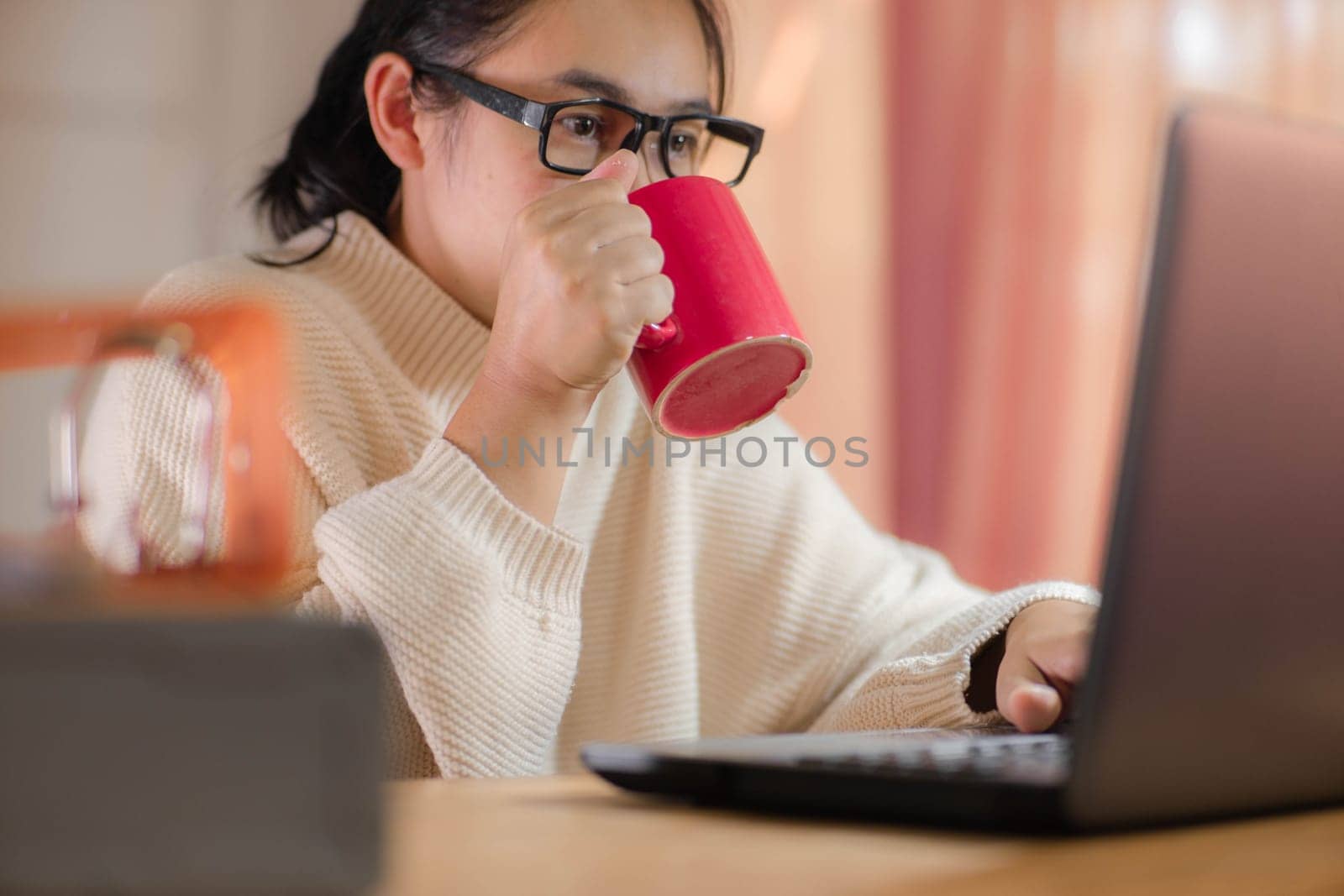 businesswoman drinking red cup of coffee at work.