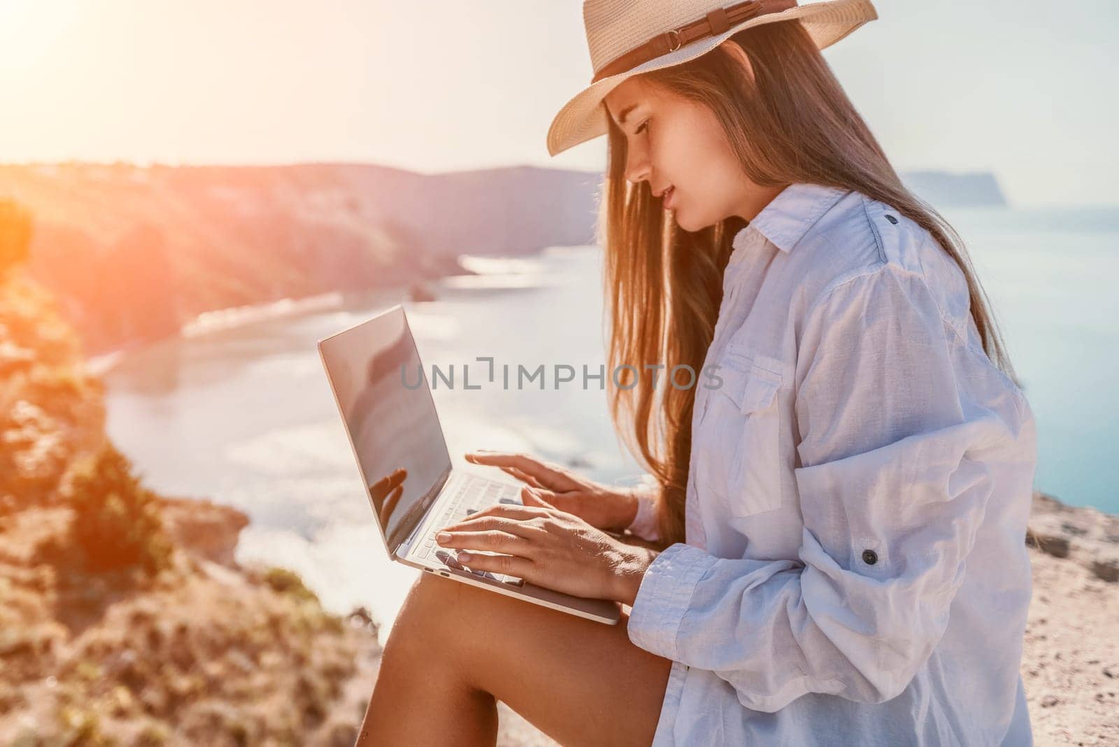 Happy girl doing yoga with laptop working at the beach. beautiful and calm business woman sitting with a laptop in a summer cafe in the lotus position meditating and relaxing. freelance girl remote work beach paradise