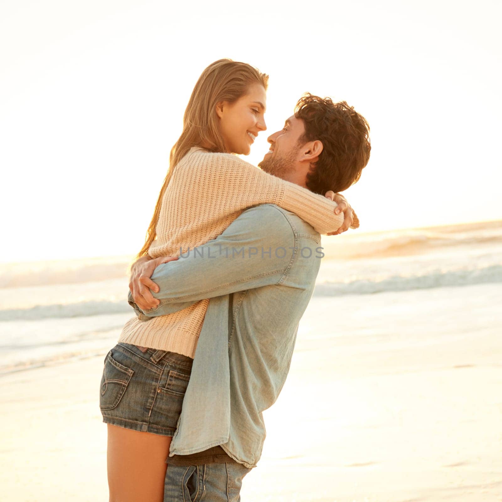 You mean the world to me...a young couple being romantic on the beach. by YuriArcurs