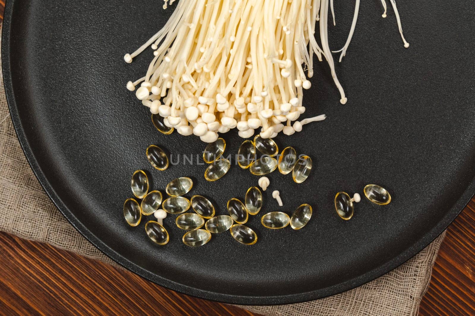 Mushroom or enoki close up, enokitake Flammulina velutipes. Capsules, dietary supplements.