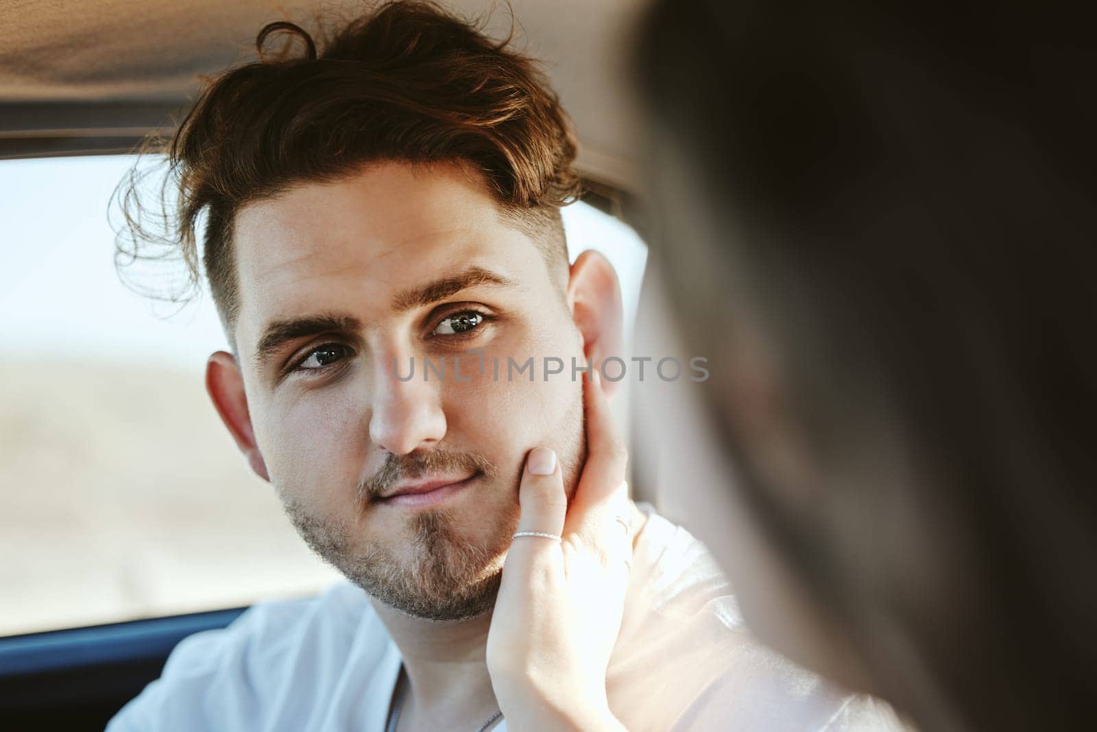 Face, love and romance with the hand of a woman on the cheek of her boyfriend in a car on a road trip for dating and travel. Couple, transport and date with a man and girlfriend in a vehicle.