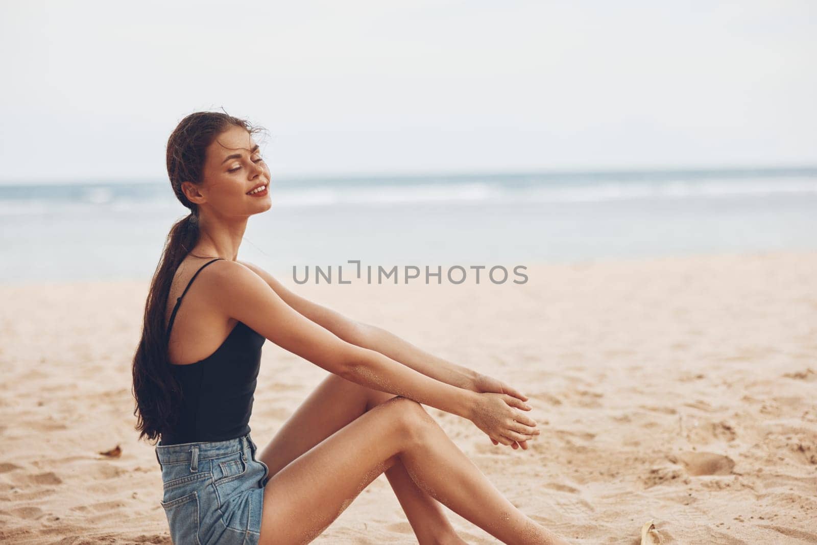 woman ocean smile sea freedom relax beach beauty sitting carefree coast summer water hair sand nature female tan travel holiday long vacation