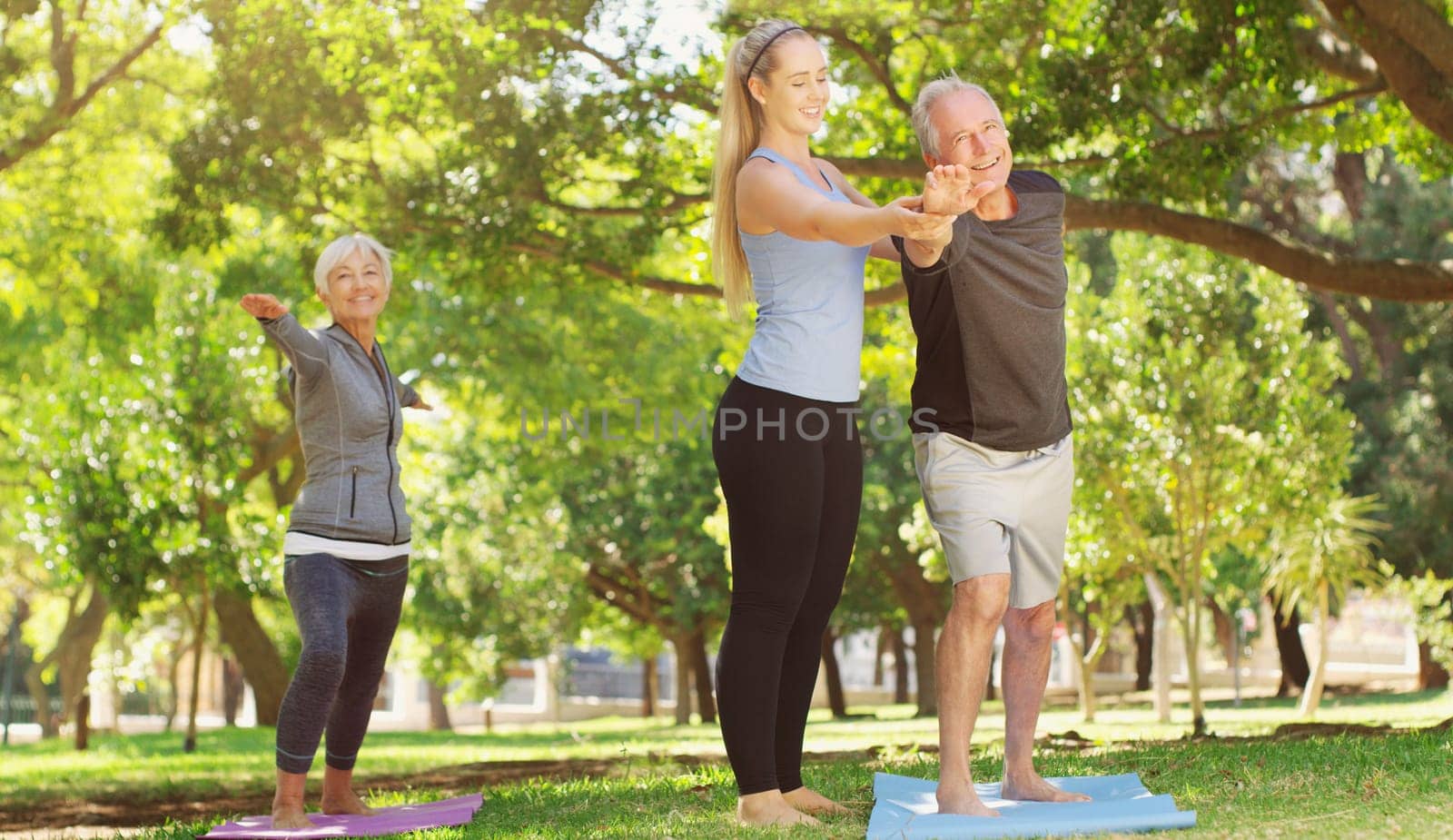 Yoga, wellness and an old couple with their personal trainer in a park for a health or active lifestyle. Exercise, fitness or zen and senior people outdoor for a workout with their pilates coach by YuriArcurs