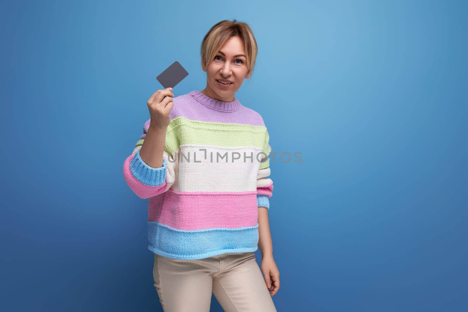 girl holding a credit card with a mockup on a blue background.