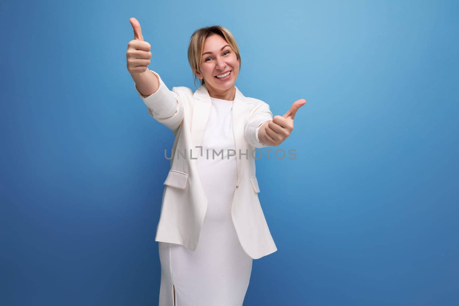 elegant blonde young european woman dressed in a white jacket and dress on an isolated background.