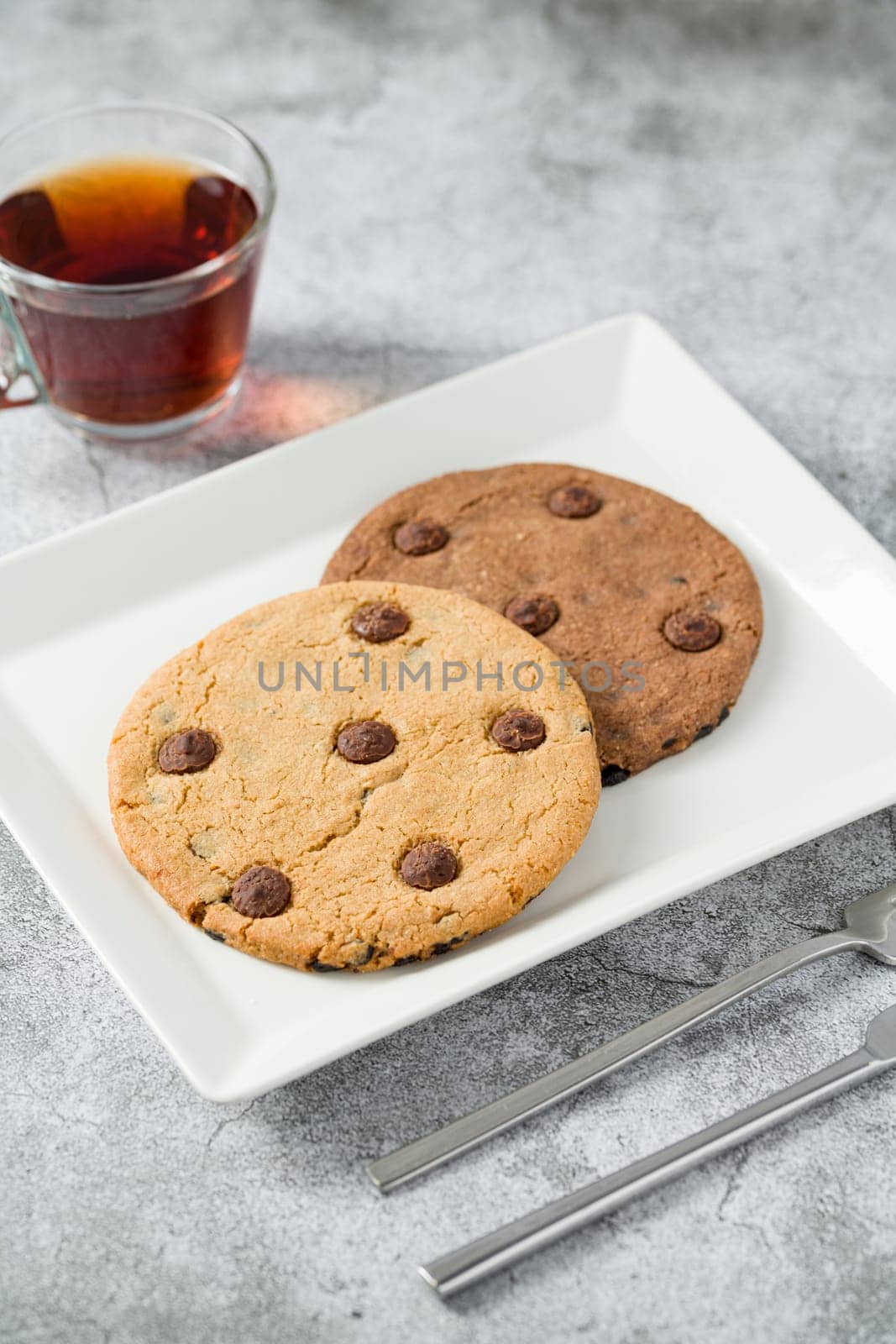 Chocolate chip cookies with tea on the stone table