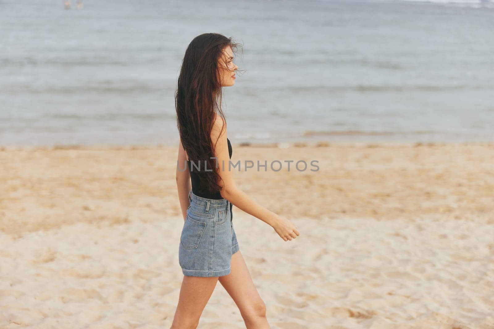 woman young holiday peaceful jean ocean outdoor adult hair free sunset lifestyle smile running sea beach sand summer long nature vacation beauty