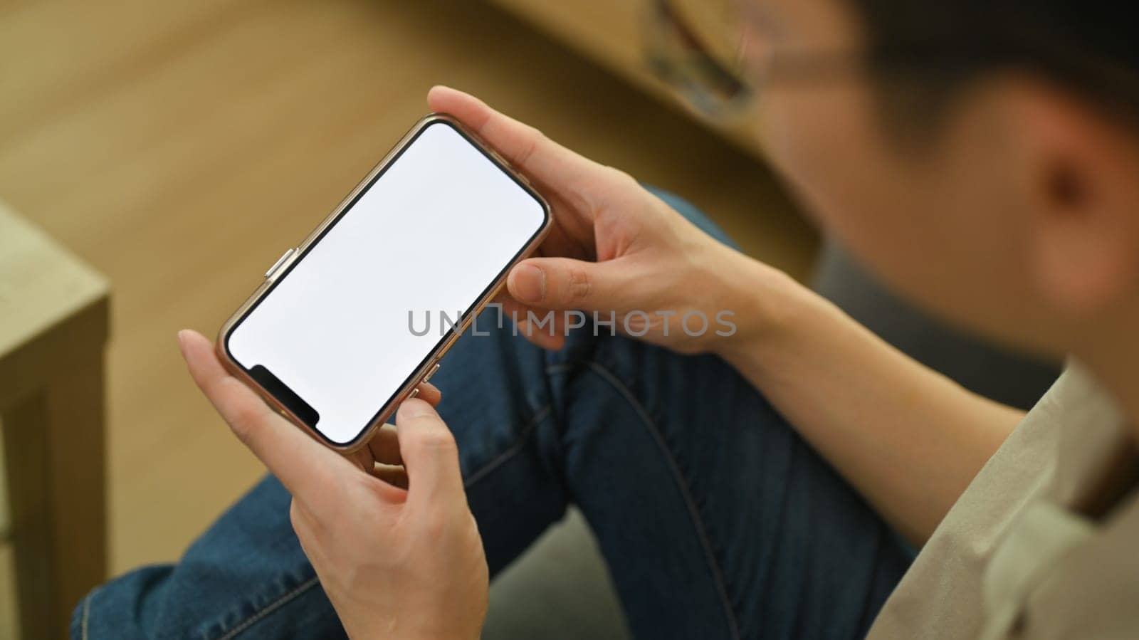 Closeup view of horizontal smartphone with blank screen in man hands. Empty space for your advertising text message.