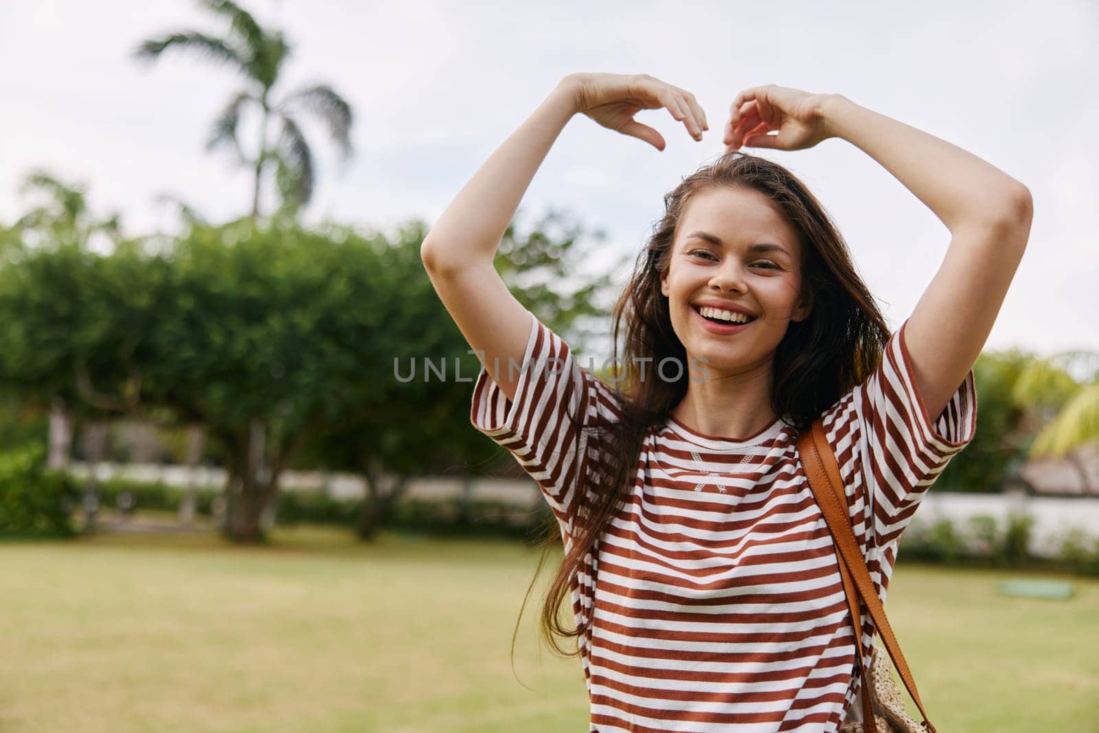 woman happy walking summer wellness walk care t-shirt outdoor health beauty beautiful freedom meditation park natural bali smile smiling nature lifestyle carefree