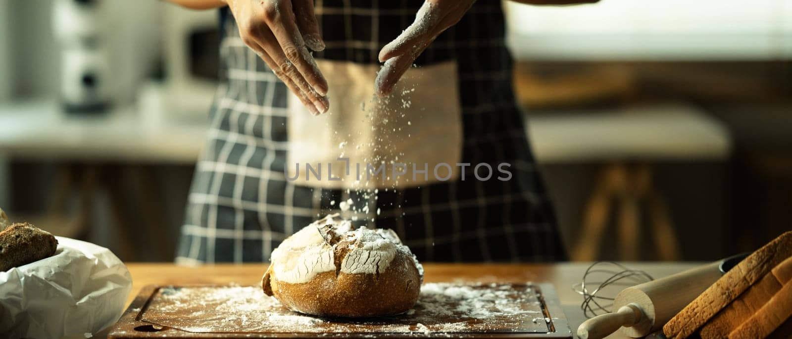 Shot of unrecognizable baker in apron preparing dough pastry with white flour.