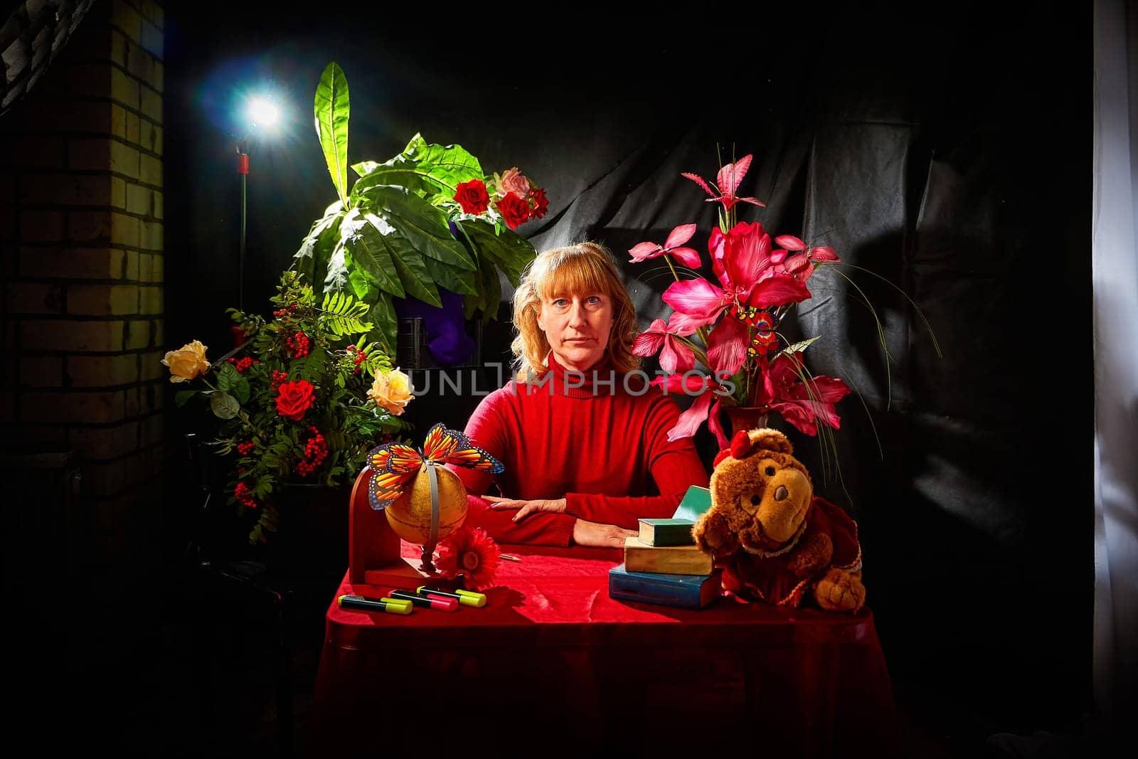 Woman in Frame, background, abstract picture, location for a photo shoot with flowers, a monkey toy, a globe. The concept of study. The holiday is the Day of knowledge on September 1 by keleny