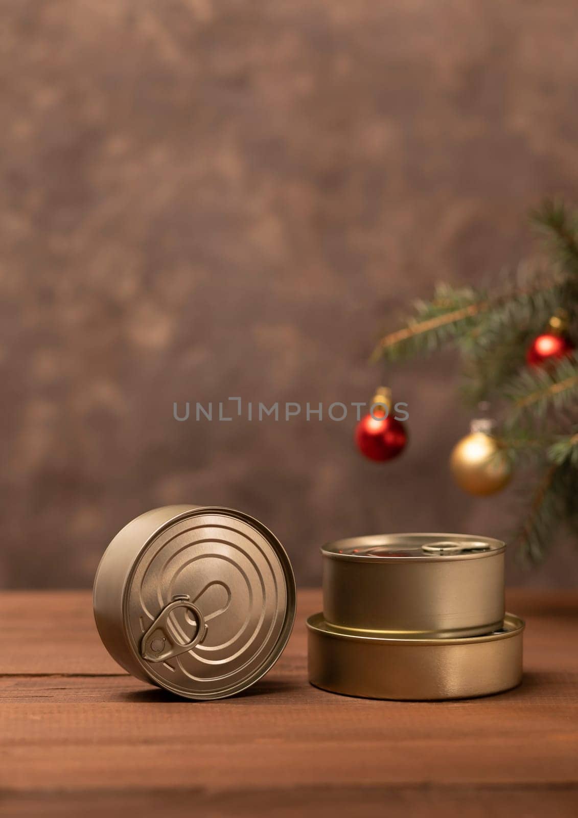 Christmas canned food, products, preservation, packed fish, meat, vegetables in can on wooden table Christmas tree and toy balls. Copy space. New Year food concept. Vertical plane, space for text