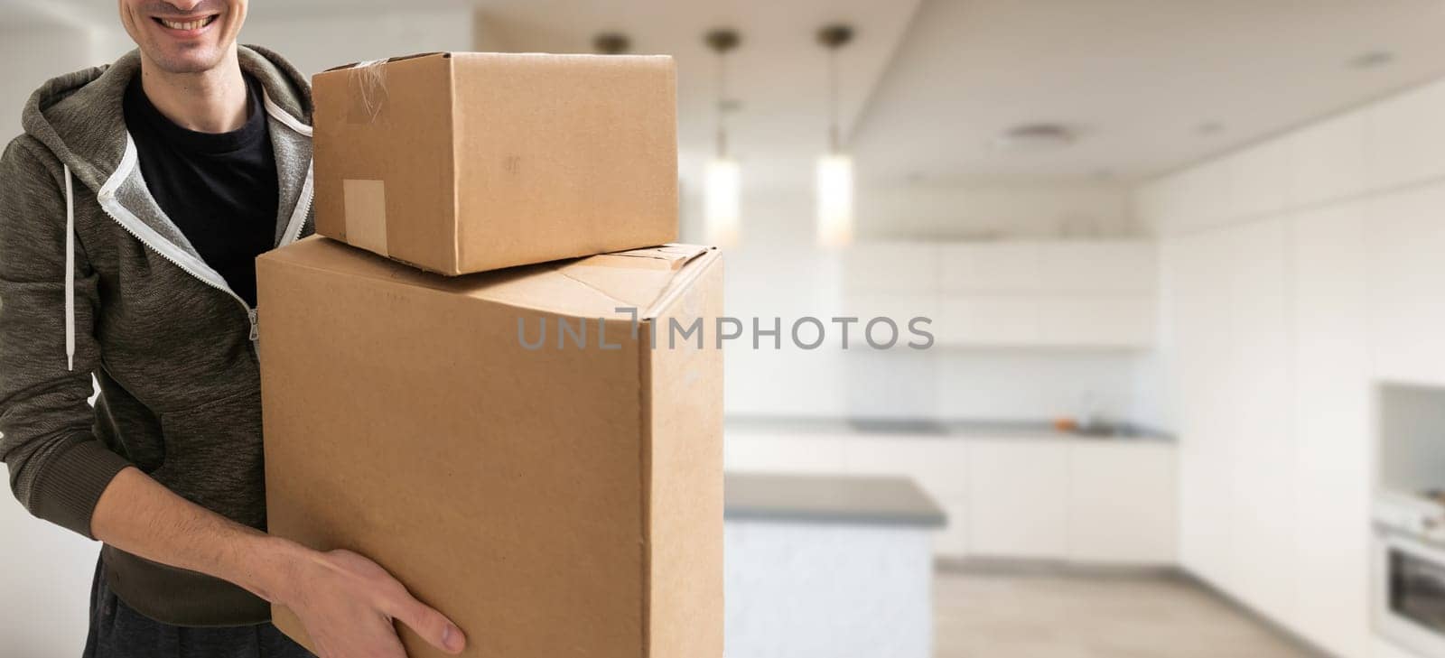 young man carries moving boxes.