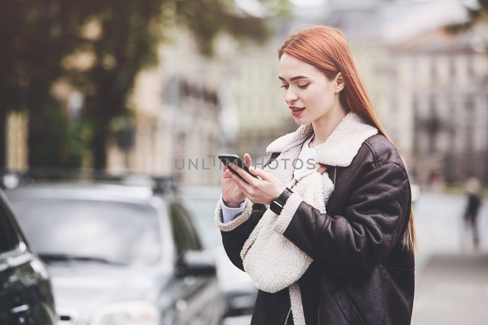 happy woman communicates with friends via video link outdoors on an old town street.