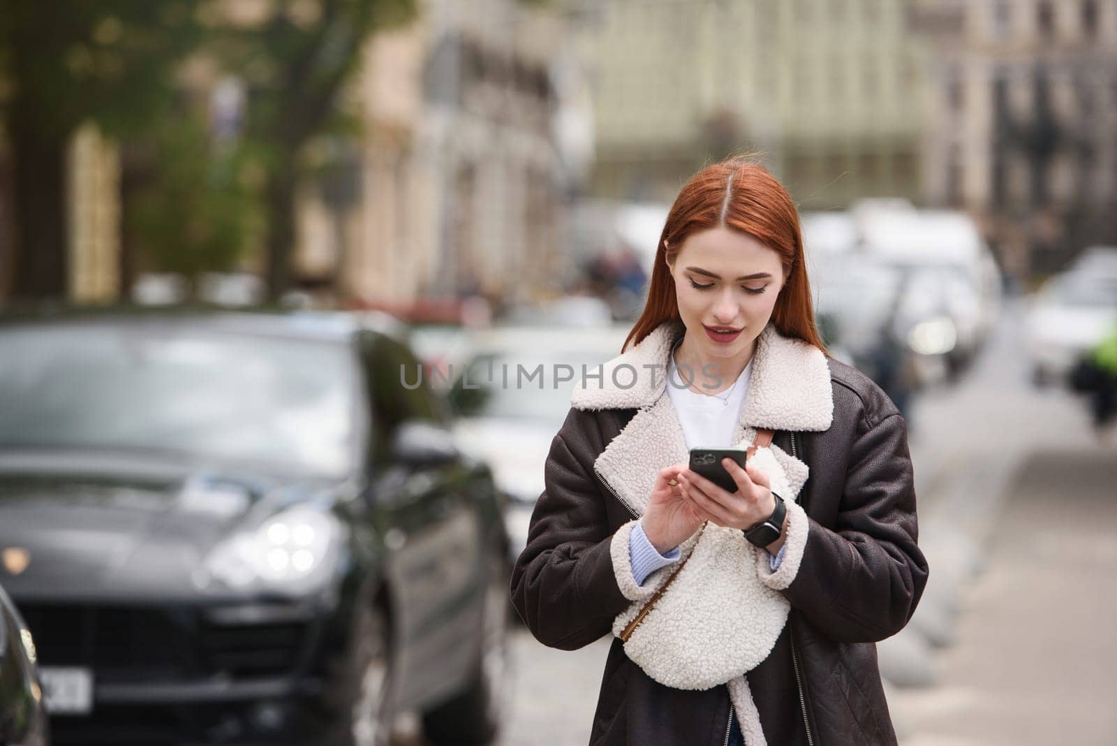 happy woman communicates with friends via video link outdoors on an old town street.