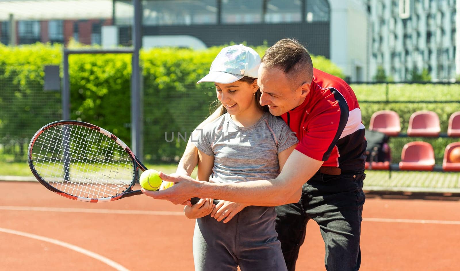 Active family playing tennis on court.