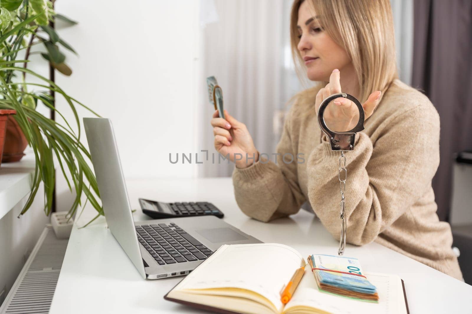 handcuff and money on laptop, Buying freedom, exchange freedom for money to escape from crime.