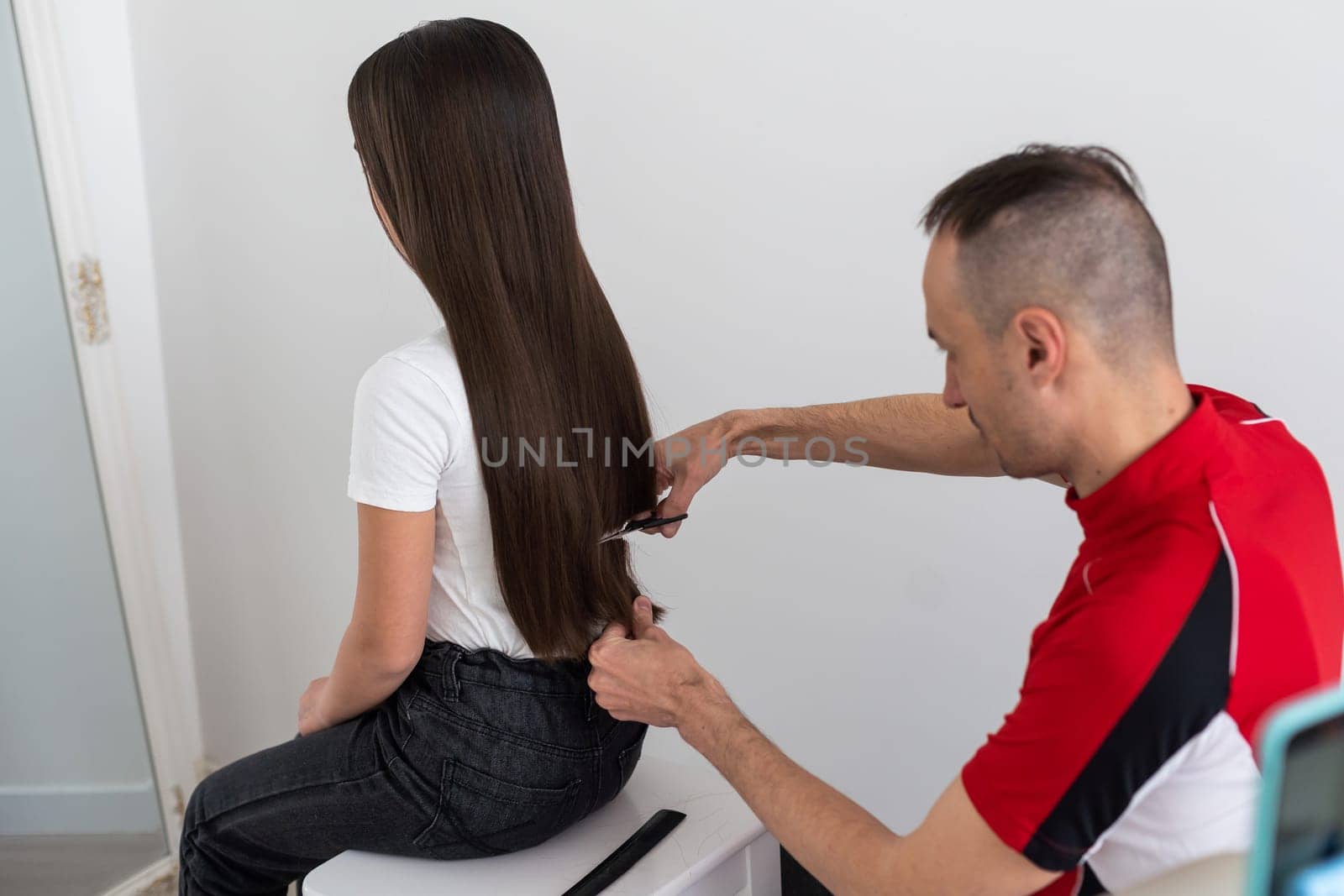 Hairdresser cutting client's hair in beauty salon.