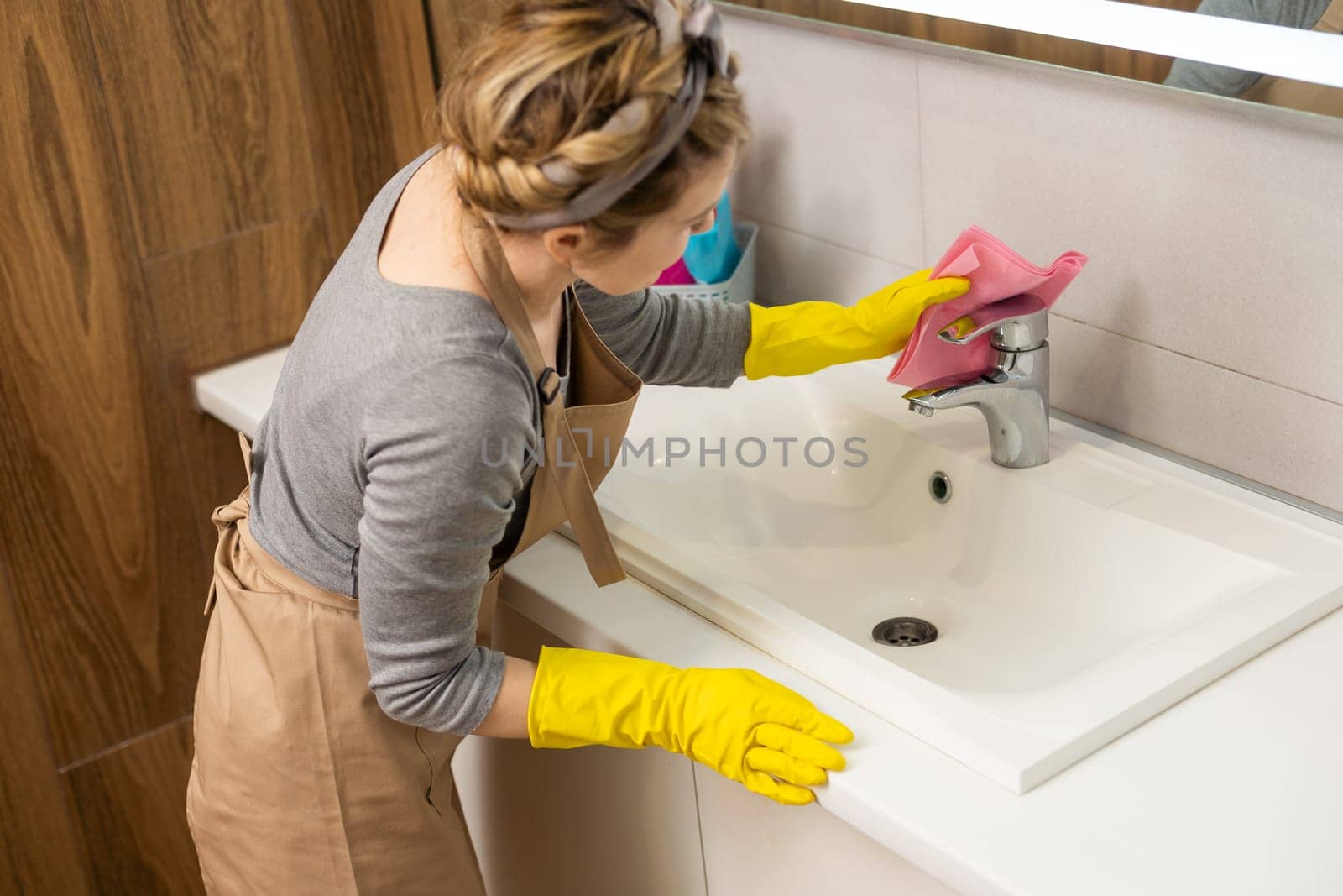 Woman cleaning and polishing the kitchen worktop with a spray detergent, housekeeping and hygiene concept. by Andelov13