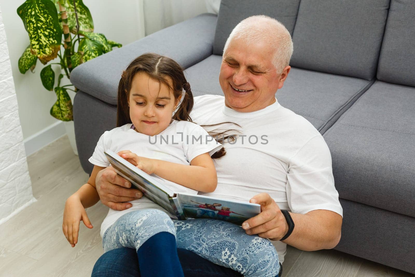 Senior man showing photos to his granddaughter.