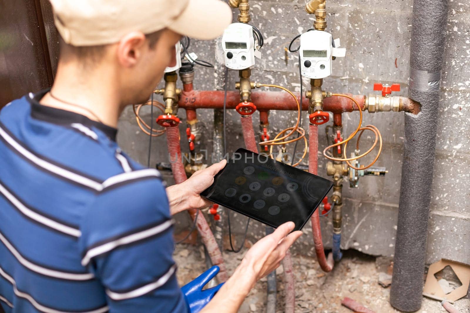 The technician checking the heating system in the boiler room with tablet in hand.