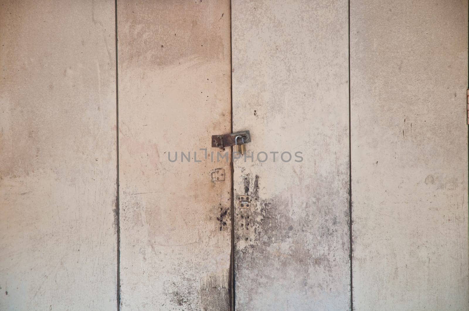 Locked key of wooden grey white door panes of an old house