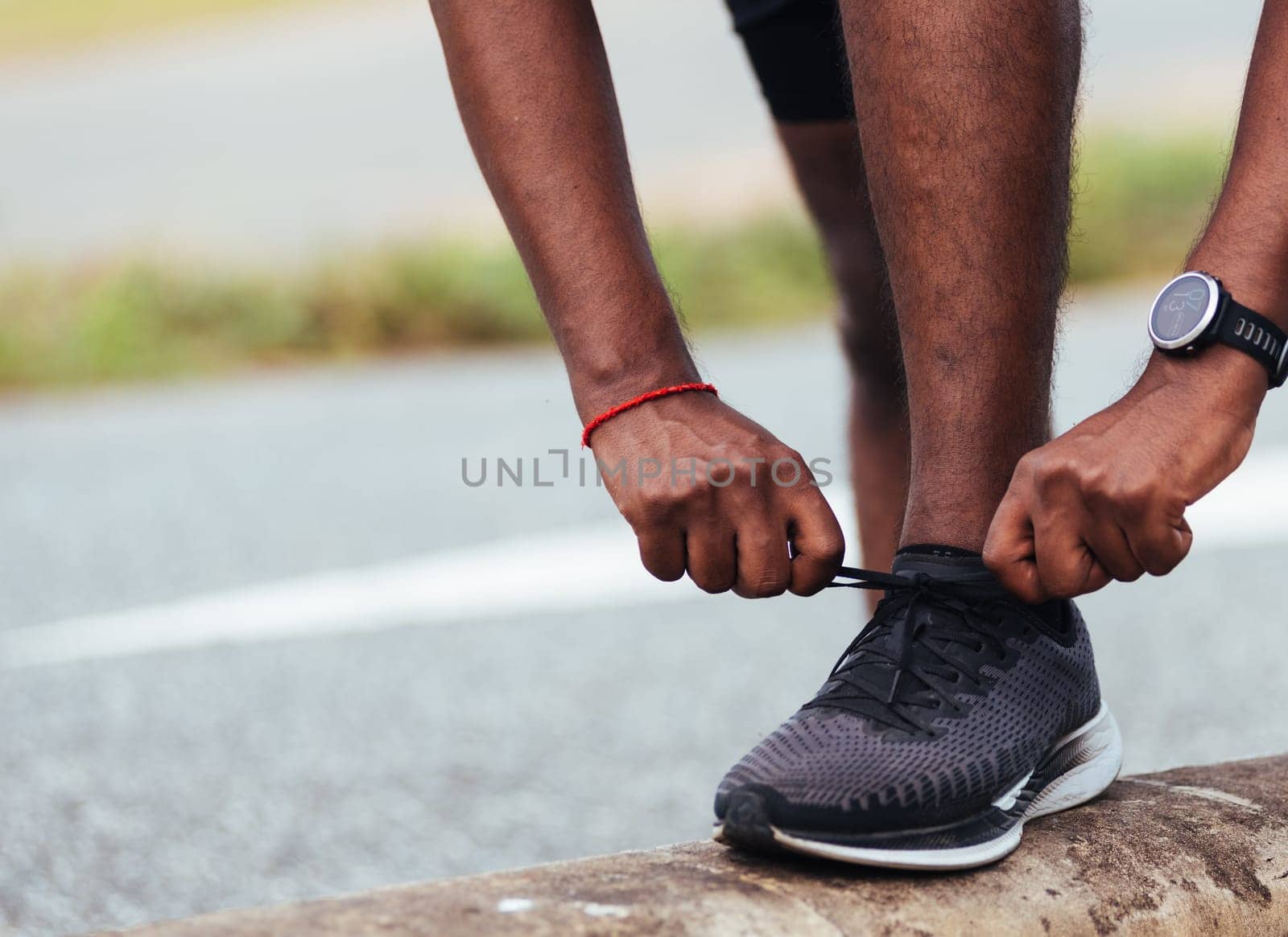 Close up Asian sport runner black man wear watch stand step on the footpath trying shoelace running shoes getting ready for jogging and run outdoor street health park, healthy exercise workout concept