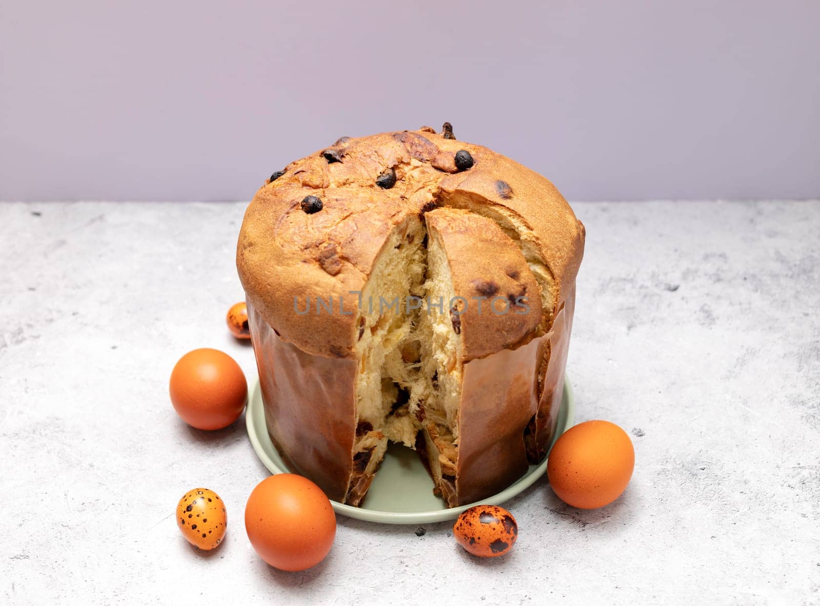 Easter Panettone Italian Cake On Table With Colored Easter Hen Eggs. Fruitcake, Sweet Bread, Originally From Milan, Italy. Pastry Dessert. Pasqua Christian Festival, Cultural Holiday. Horizontal Plane