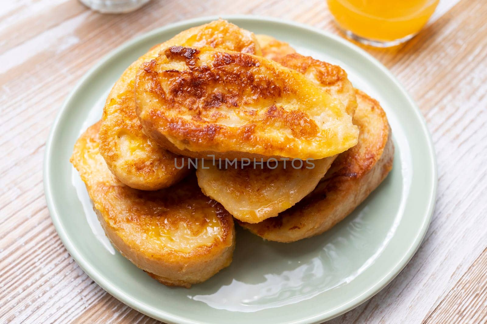 Homemade French Toast On Plate With Orange Syrup On Wooden Table. Spanish Tarija Toasts Top View. Horizontal Plane. Traditional Breakfast. High quality photo