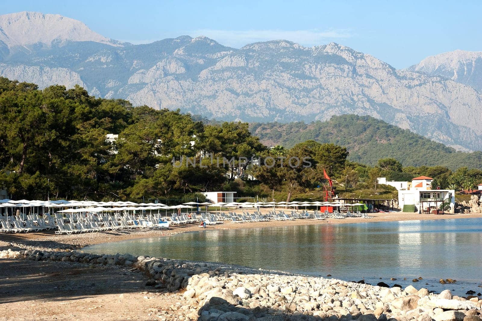 Nice view of Kemer beach with sand and mountains. Beautiful harbor near the sandy beach.