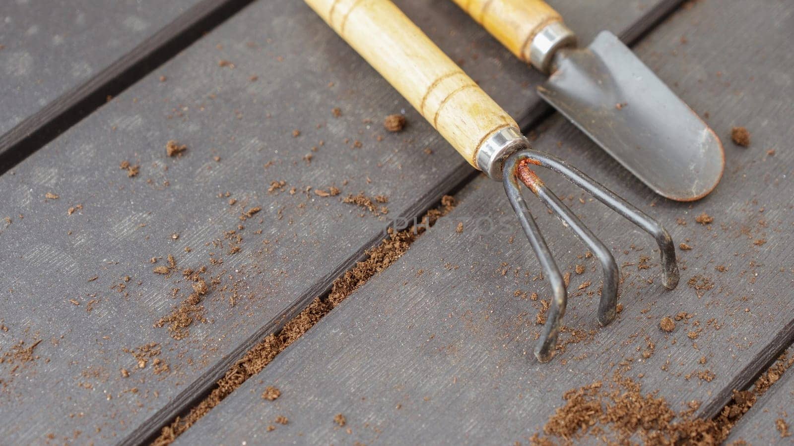 Close up of old used garden tools shovel and rake, top view, selective focus. Spring natural gardening, eco, plant care, organic product.